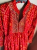 Picture of Red Bandhini dress with mirror work on yoke