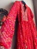 Picture of Red Bandhini dress with mirror work on yoke