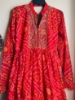 Picture of Red Bandhini dress with mirror work on yoke